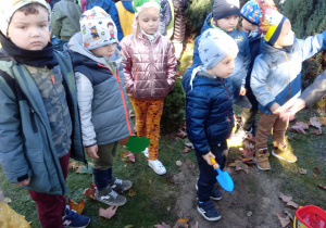 Dzieci sadzą krzewy w ogrodzie przedszkolnym